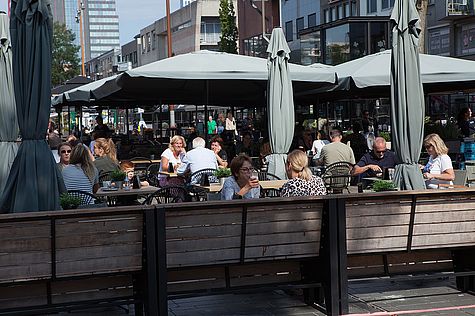 Mensen in de zon op het terras in Almere Stad